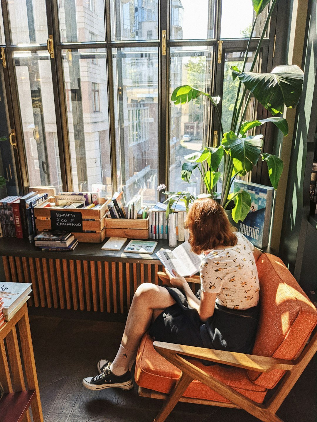 Woman writing in a journal by a sunny window