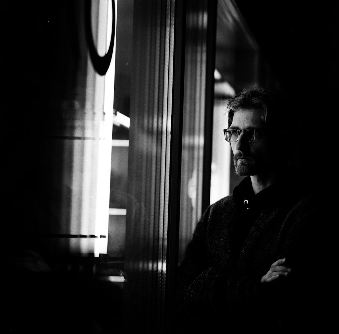 Man sitting quietly by a window in thought